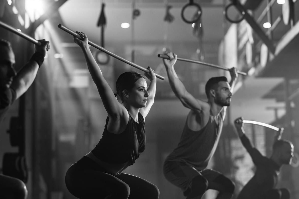 fotografia-blanco-negro-personas-atleticas-haciendo-ejercicio-varillas-entrenamiento-cruzado-gimnasio.jpg