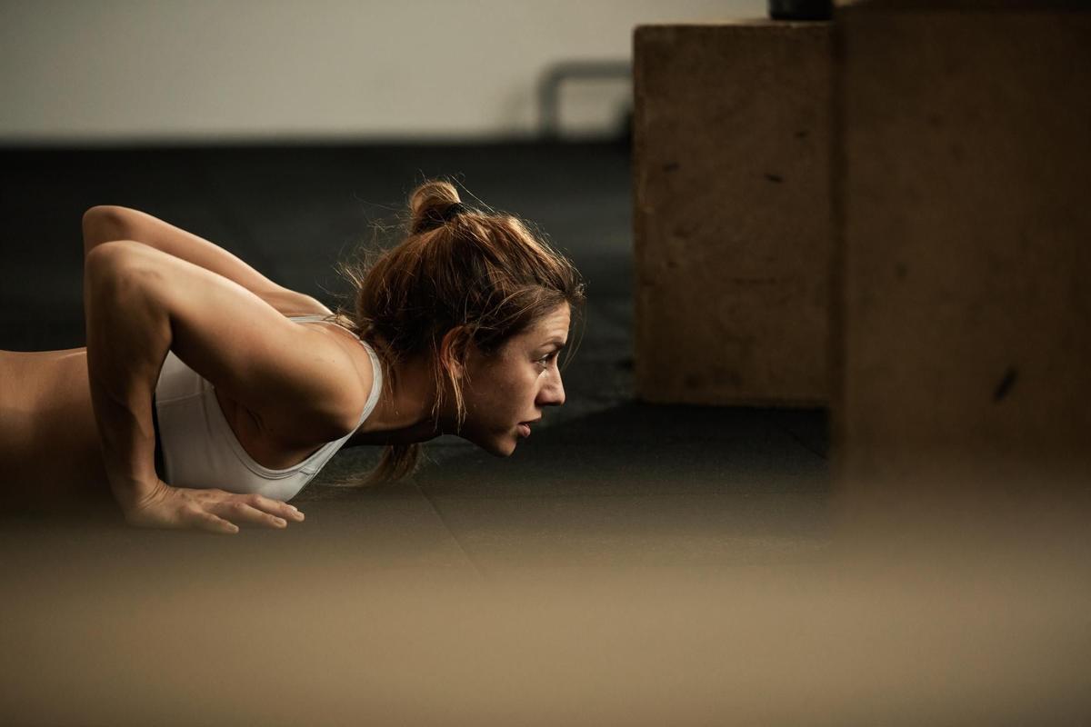 joven-deportista-dedicada-ejerciendo-flexiones-entrenamiento-deportivo-club-salud-copiar-espacio.jpg